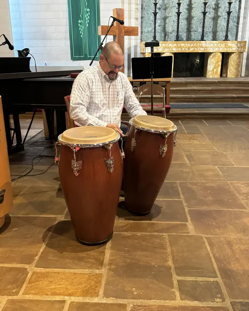 Hermano tocando las congas durante la alabanza
