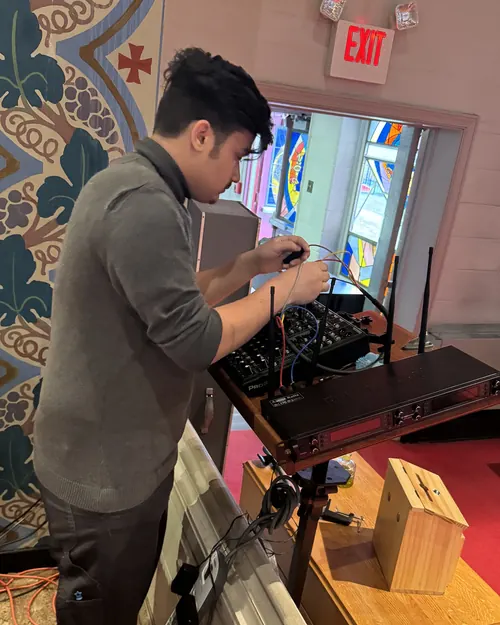 Hermano operando la consola de sonido durante el servicio
